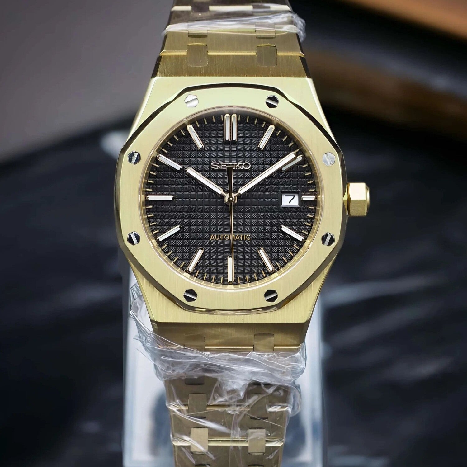 Front view of Seiko Mod Royal Oak in yellow gold, highlighting the textured black dial, luminous indices, and polished case.