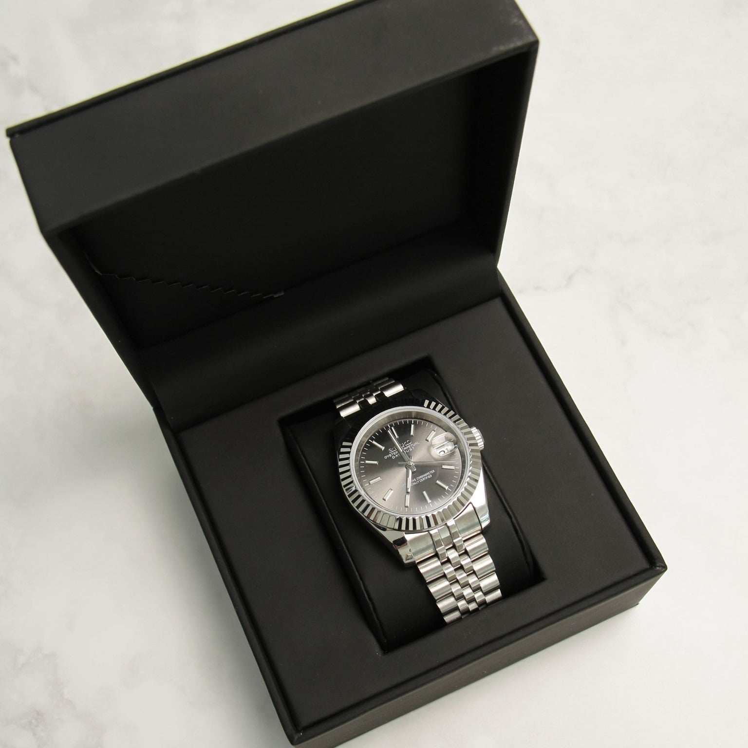 Seiko Mods Datejust Grey Box top view watch in black box focus on case shape and jubilee bracelet
