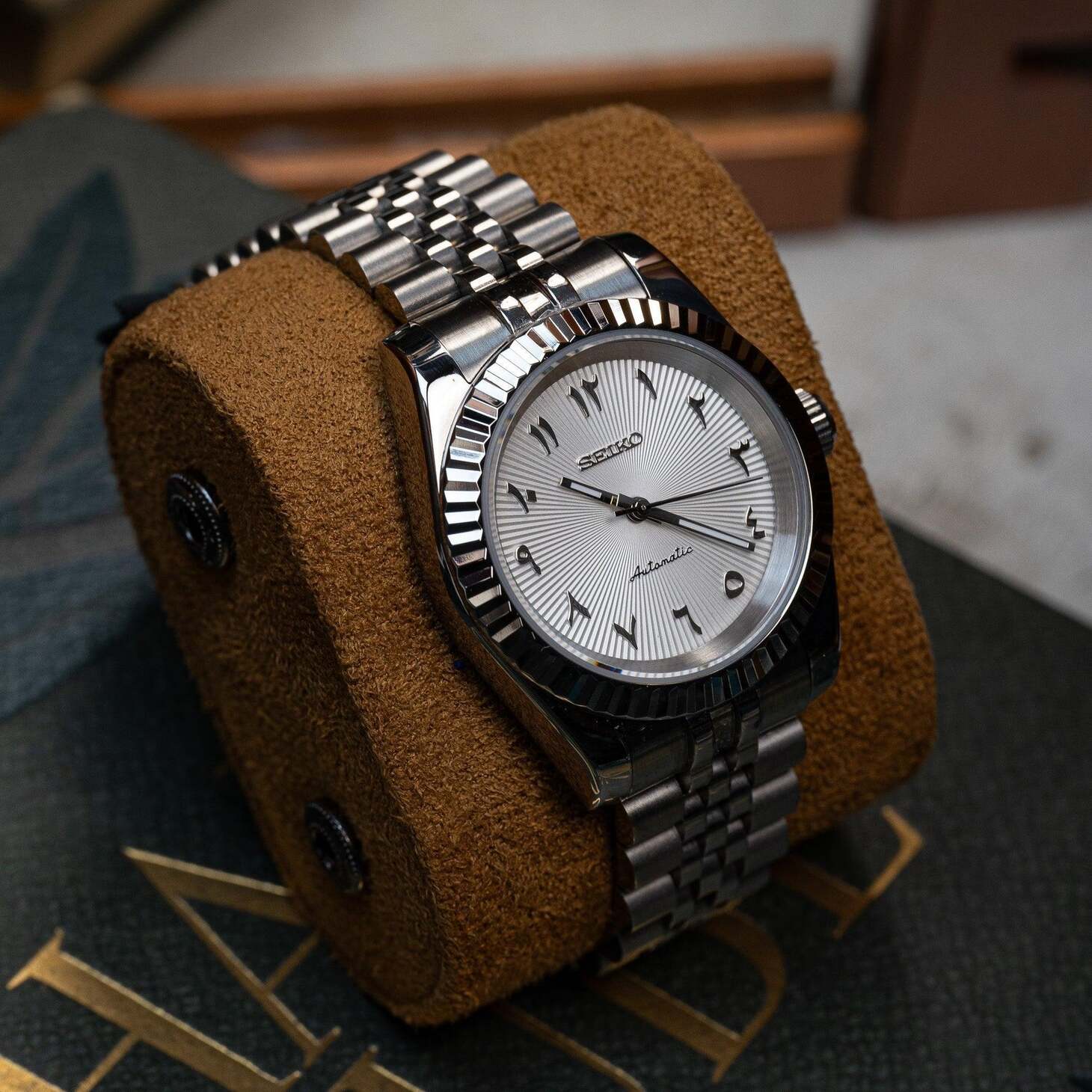 Seiko Mod Datejust White Textured Arabic left angle emphasizing case reflection and detailed steel bracelet links.