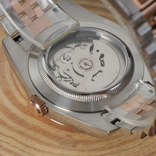 Seiko mod Datejust Wimbledon open case back reveals automatic movement on wood