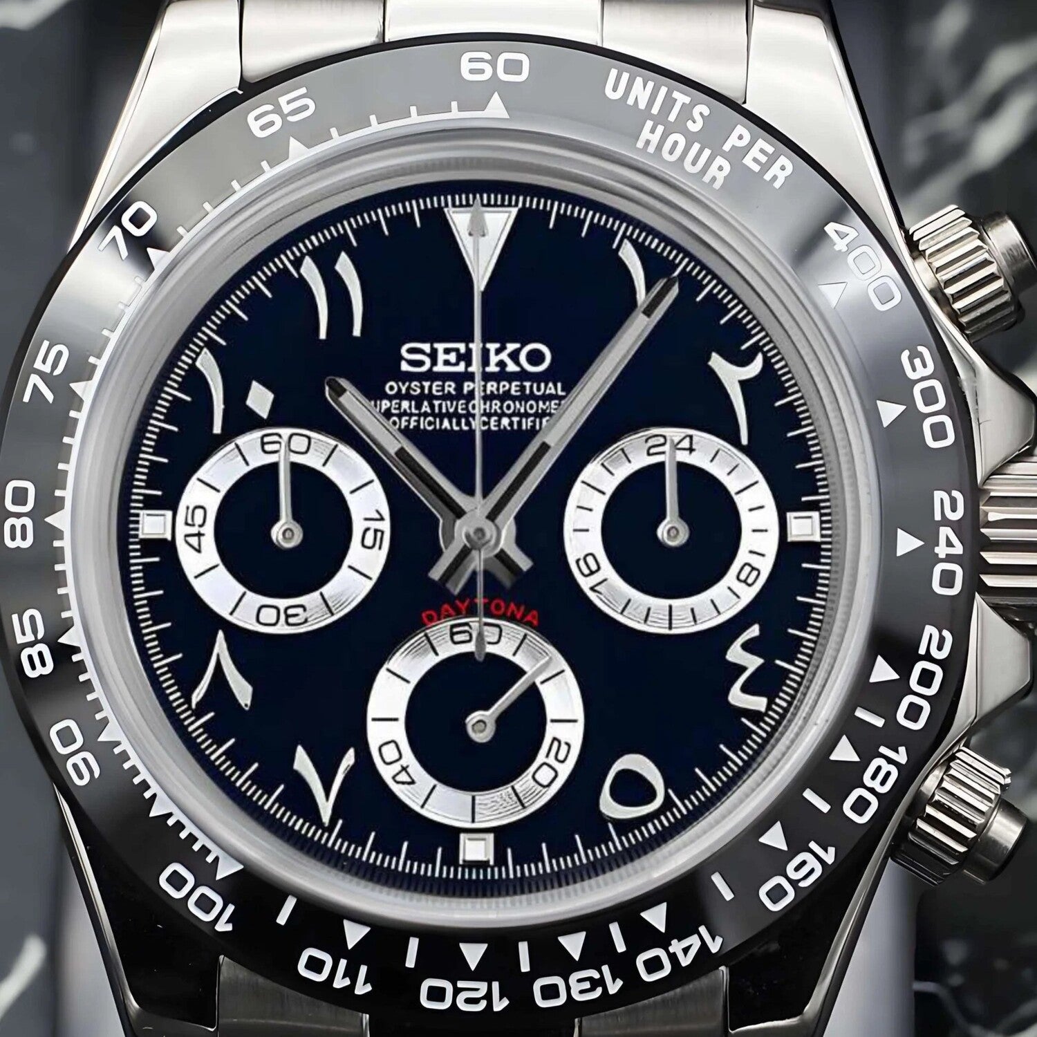 Close up Seiko Mod Daytona Black Arabic dial with silver subdials, ceramic bezel and luminous hour markers.