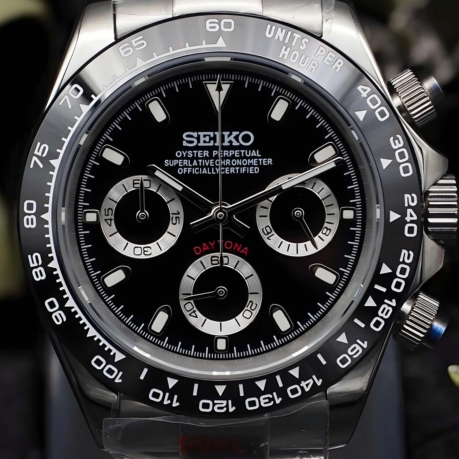 Close up front view of the Seiko Mod Daytona homage, highlighting the glossy black dial with silver panda-style subdials, bold tachymeter bezel, and polished steel chronograph pushers, captured in crisp detail to showcase its sporty elegance.