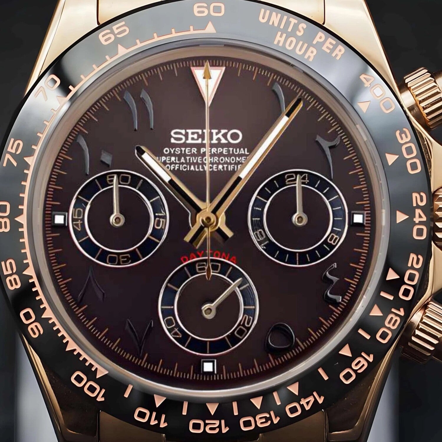 Detailed close-up of a Seiko Mod Daytona watch with a brown Arabic dial, rose gold case, and black ceramic bezel.