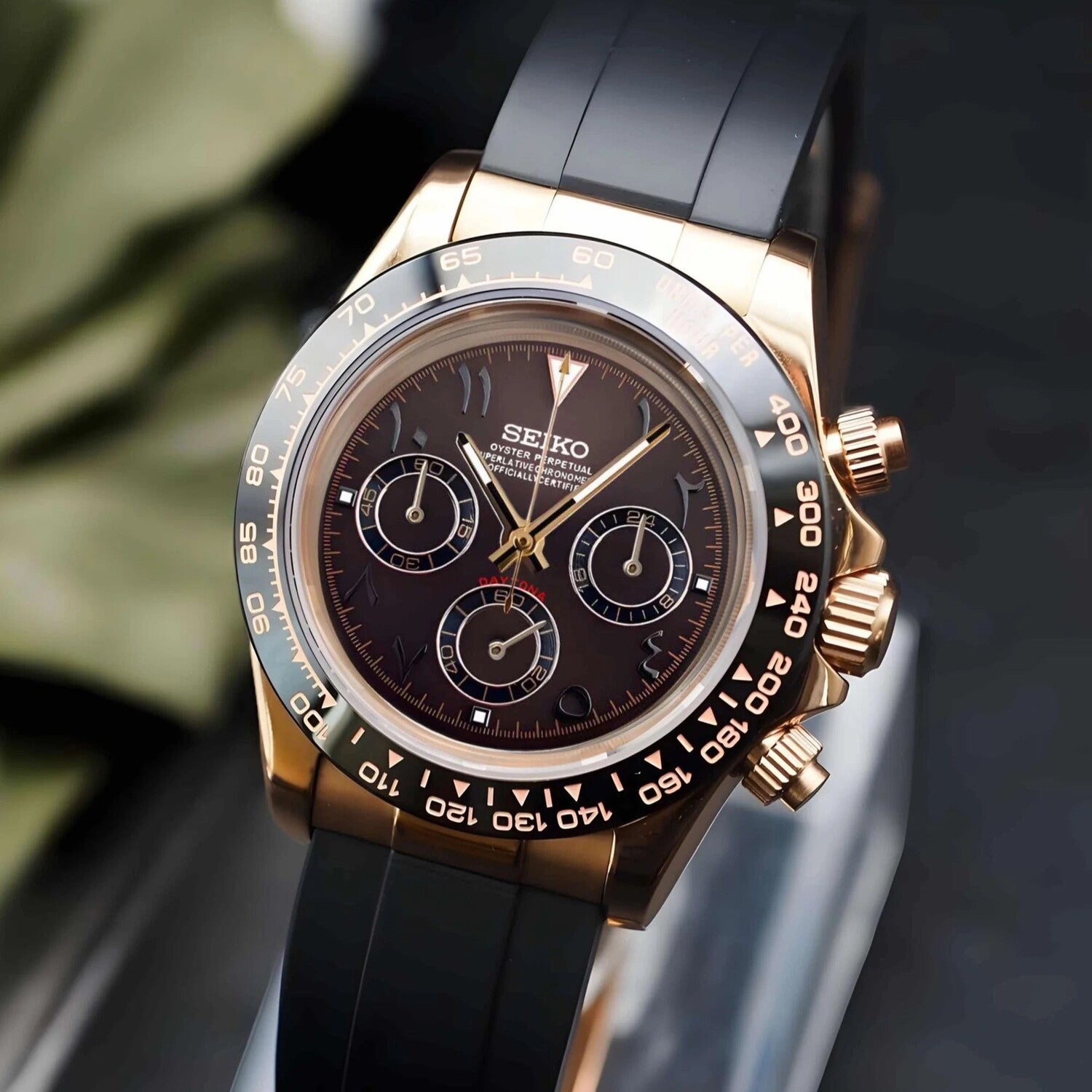Seiko Mod Daytona with brown Arabic dial and rose gold case, viewed from right angle highlighting bezel engravings.