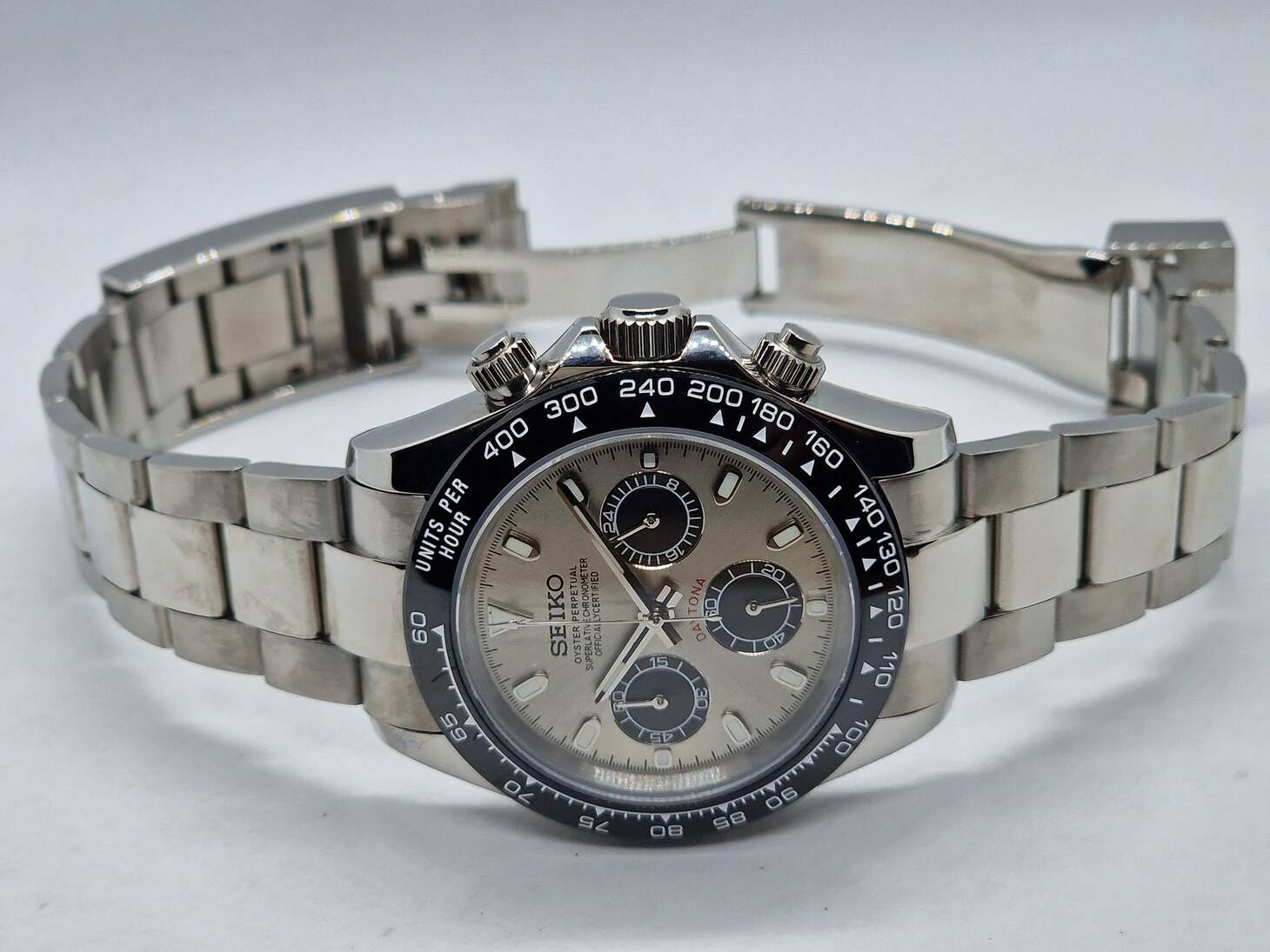Angled view of Seiko Moddys Daytona with champagne dial, contrasting black subdials, ceramic tachymeter bezel and stainless steel bracelet