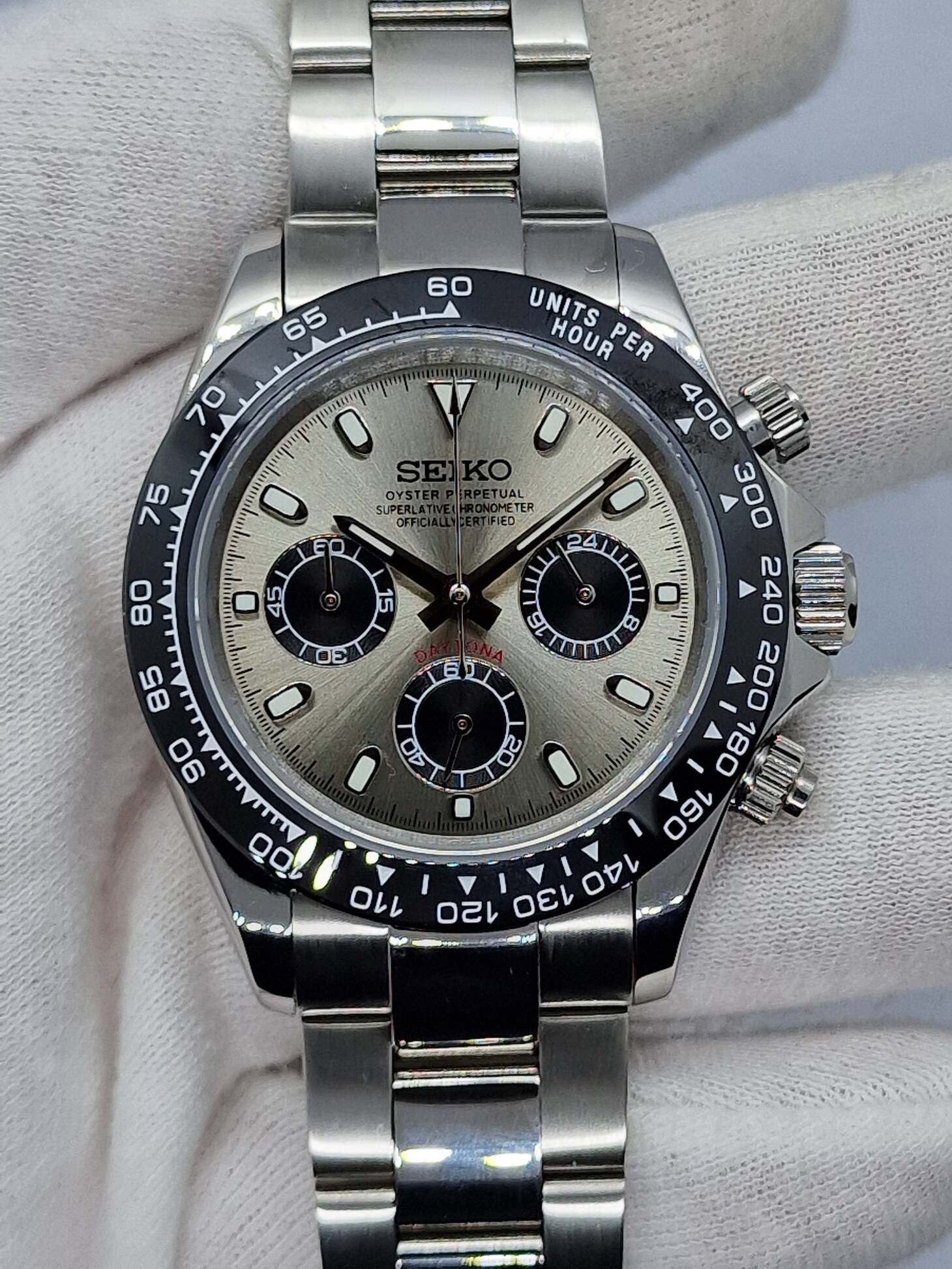 Front view of Seiko Mod Daytona with champagne dial and black subdials, polished steel bracelet.