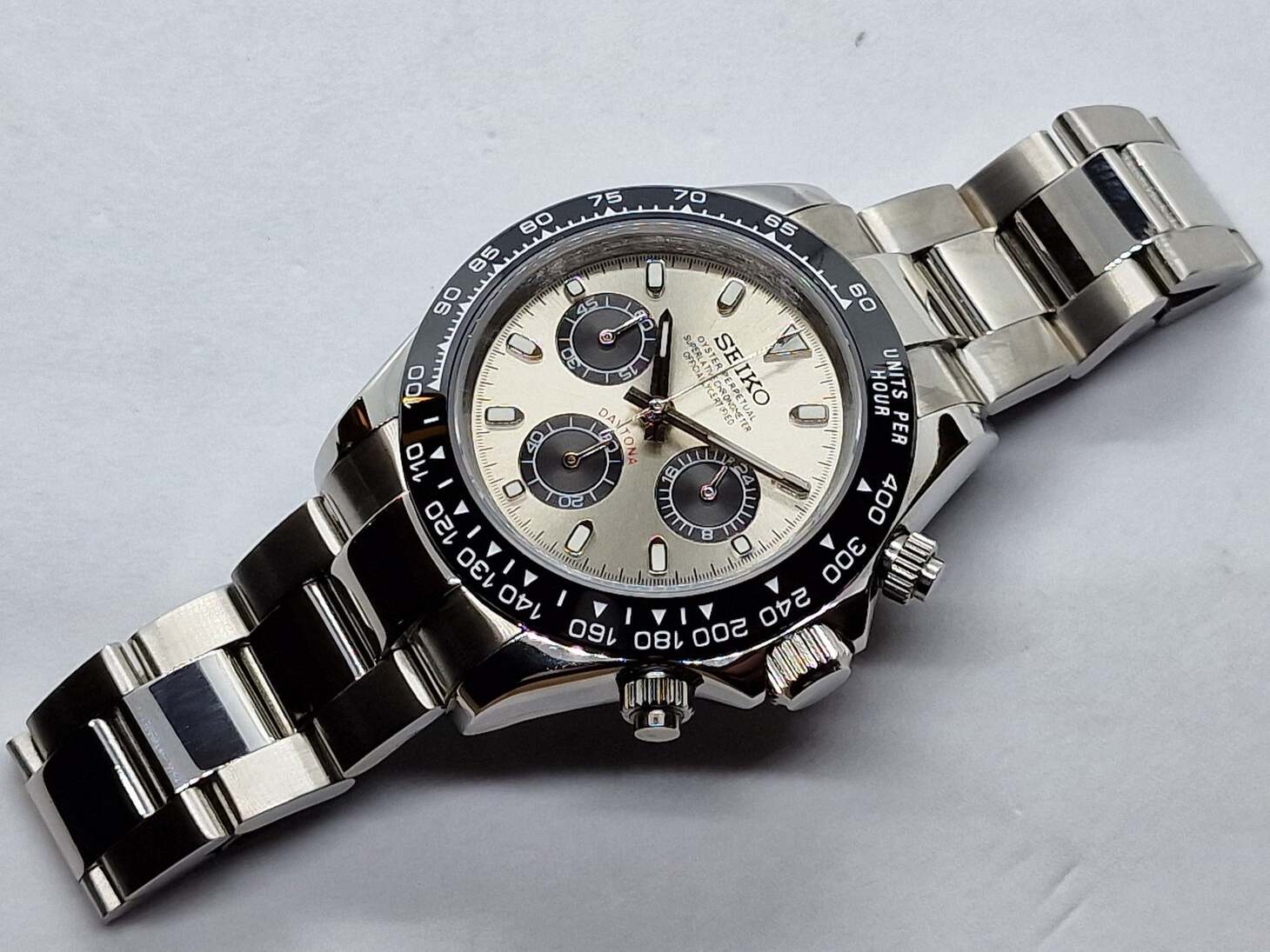 Top view of Seiko Moddys Daytona with champagne dial, black ceramic bezel and stainless steel bracelet, showing full layout