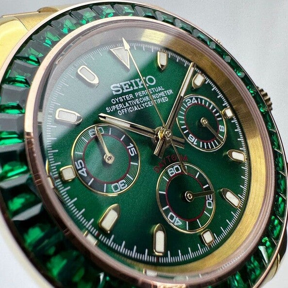 Close-up angled view of Seiko Moddys Daytona Green Emerald showing sunburst green dial, gold subdials, and emerald bezel detailing.