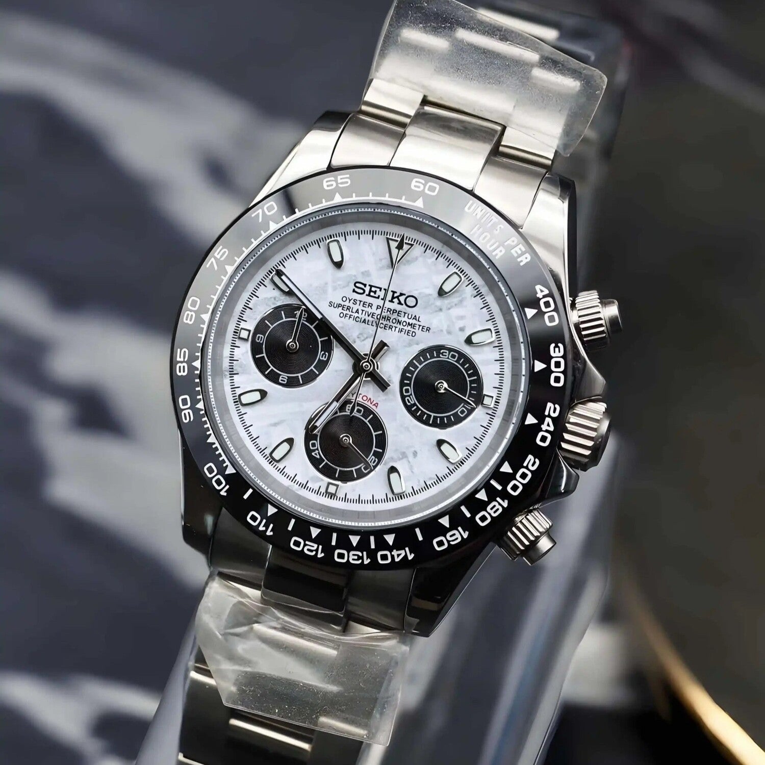 Right angled view of Seiko Mod Daytona meteorite dial, showing crown, pushers and case curvature with stainless steel bracelet.