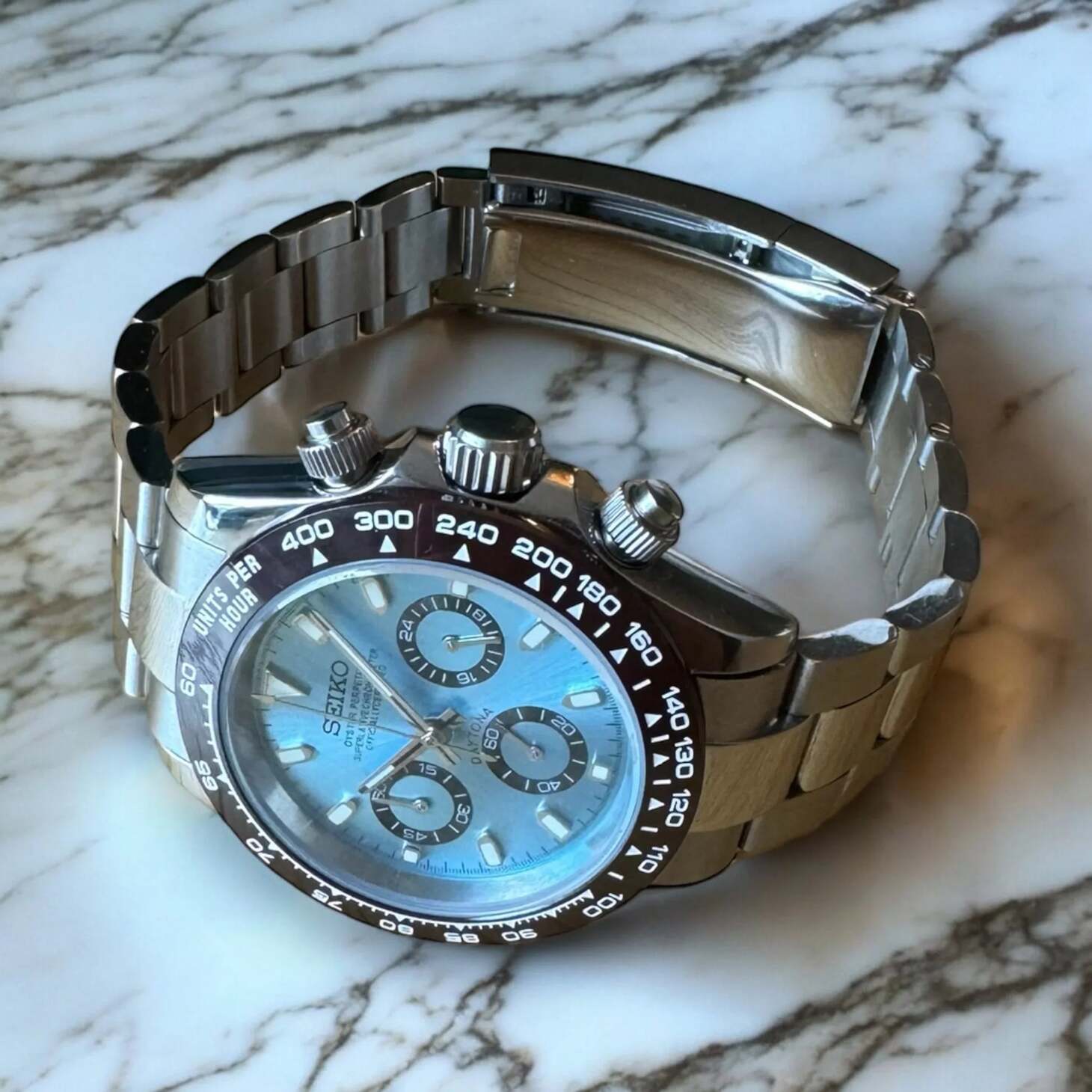 Angled view of Seiko Mod Daytona Platinum, highlighting the ice blue dial and polished crown with tachymeter bezel.