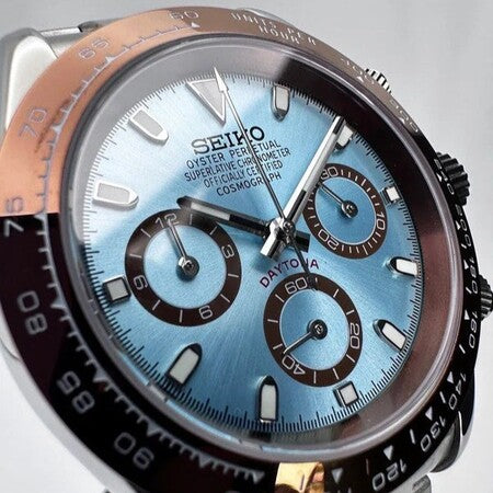 Close up of Seiko Mod Daytona Platinum dial in ice blue, showing subdials, polished indices, and brown ceramic bezel.