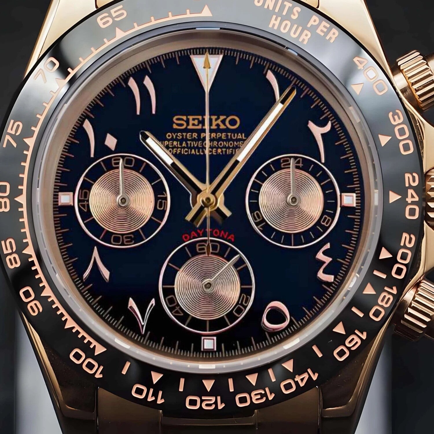 Close up view of the Seiko Mod Daytona in rose gold with black dial, Arabic numeral markers and three sunken chronograph subdials, framed by a detailed tachymeter bezel.