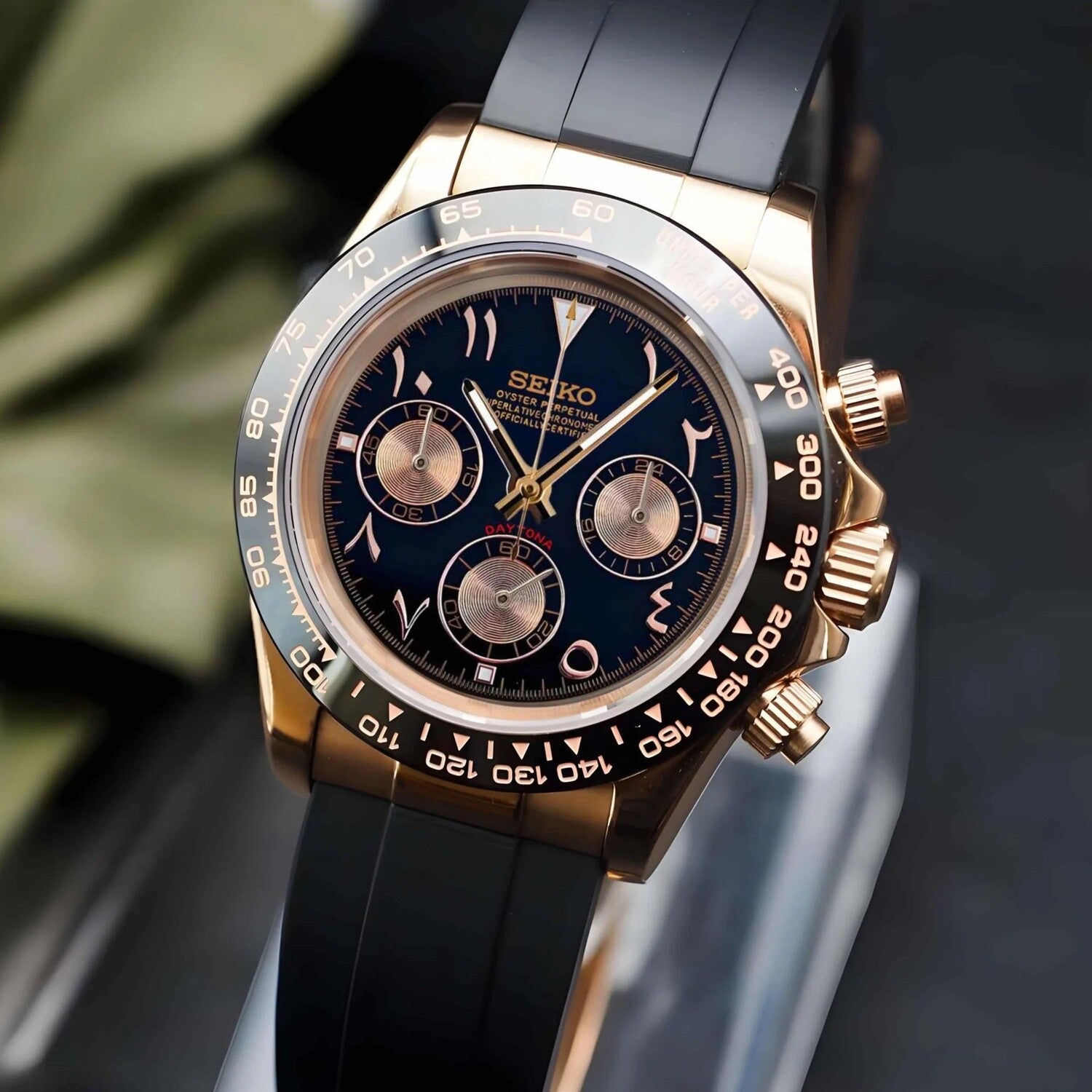 Seiko Mod Daytona Rose Gold Arabic angled view highlighting black dial with gold subdials, tachymeter bezel and black rubber strap.