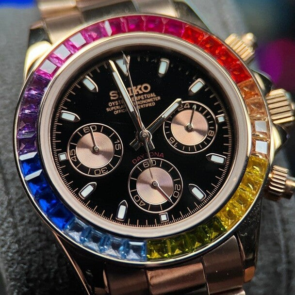 Front dial close up of the Seiko Mod Daytona Rose Gold Rainbow, highlighting the black dial, rose gold chronograph subdials, and gemstone rainbow bezel