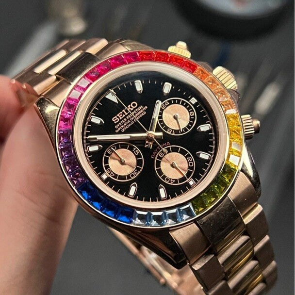 Right angled close up view of the Seiko Mod Daytona Rose Gold Rainbow, showcasing its black dial with rose gold subdials and a bezel set with multicolor rainbow gemstones.
