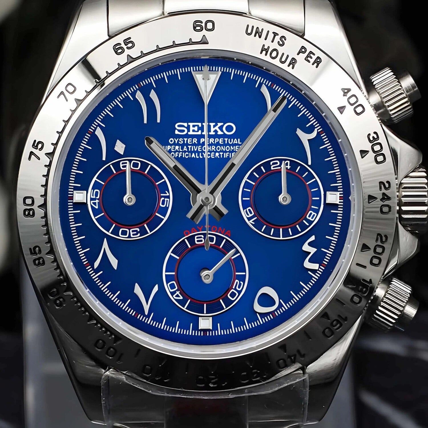 Close up of Seiko Mod Daytona Royal Blue Arabic dial, showing vibrant blue face, Arabic numerals, silver subdials with red accents, and polished steel bezel.