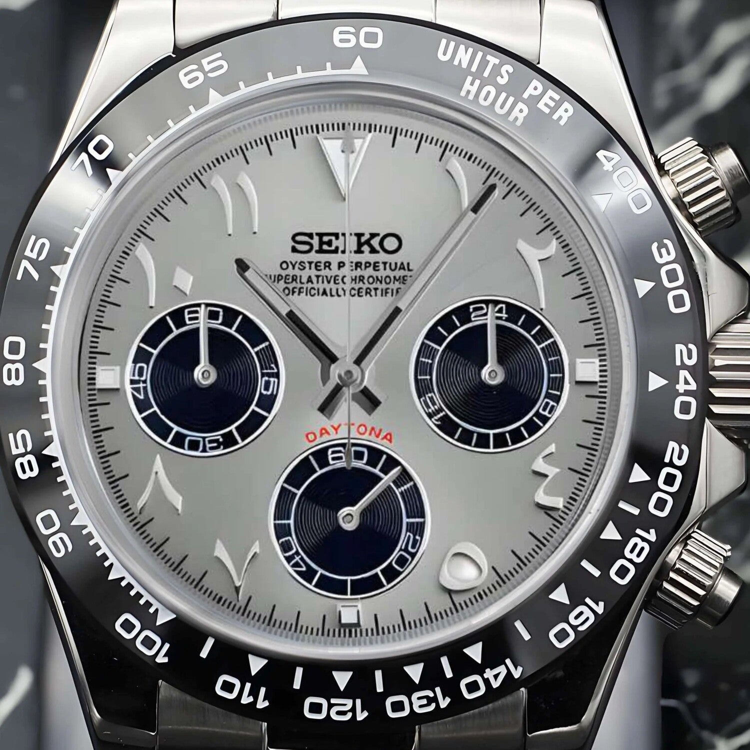 Seiko Mods Silver dial with black subdials, Arabic numerals, and a red “Daytona” inscription above the lower subdial, framed by a black tachymeter bezel.