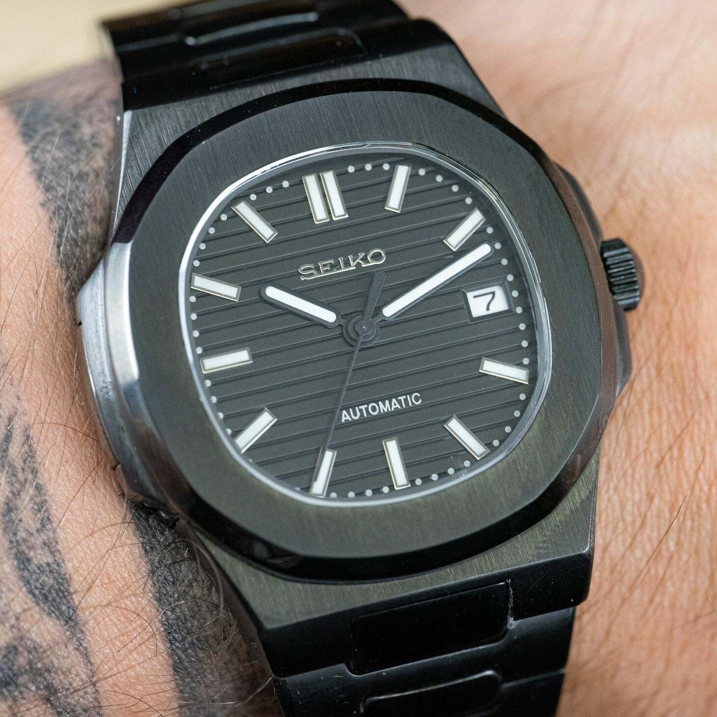 Wrist shot Seiko Mod Nautilus All Black displaying elegant contrast against skin tone