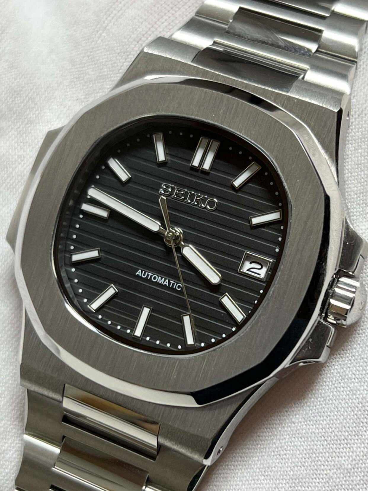 Seiko mod Nautilus black dial front view with striped texture and applied indices