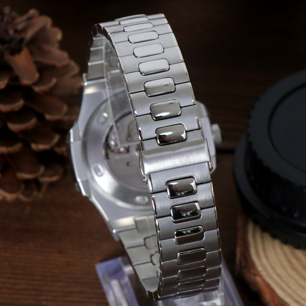 Bracelet of Seiko mod Nautilus cream edition showing polished center links on wood background