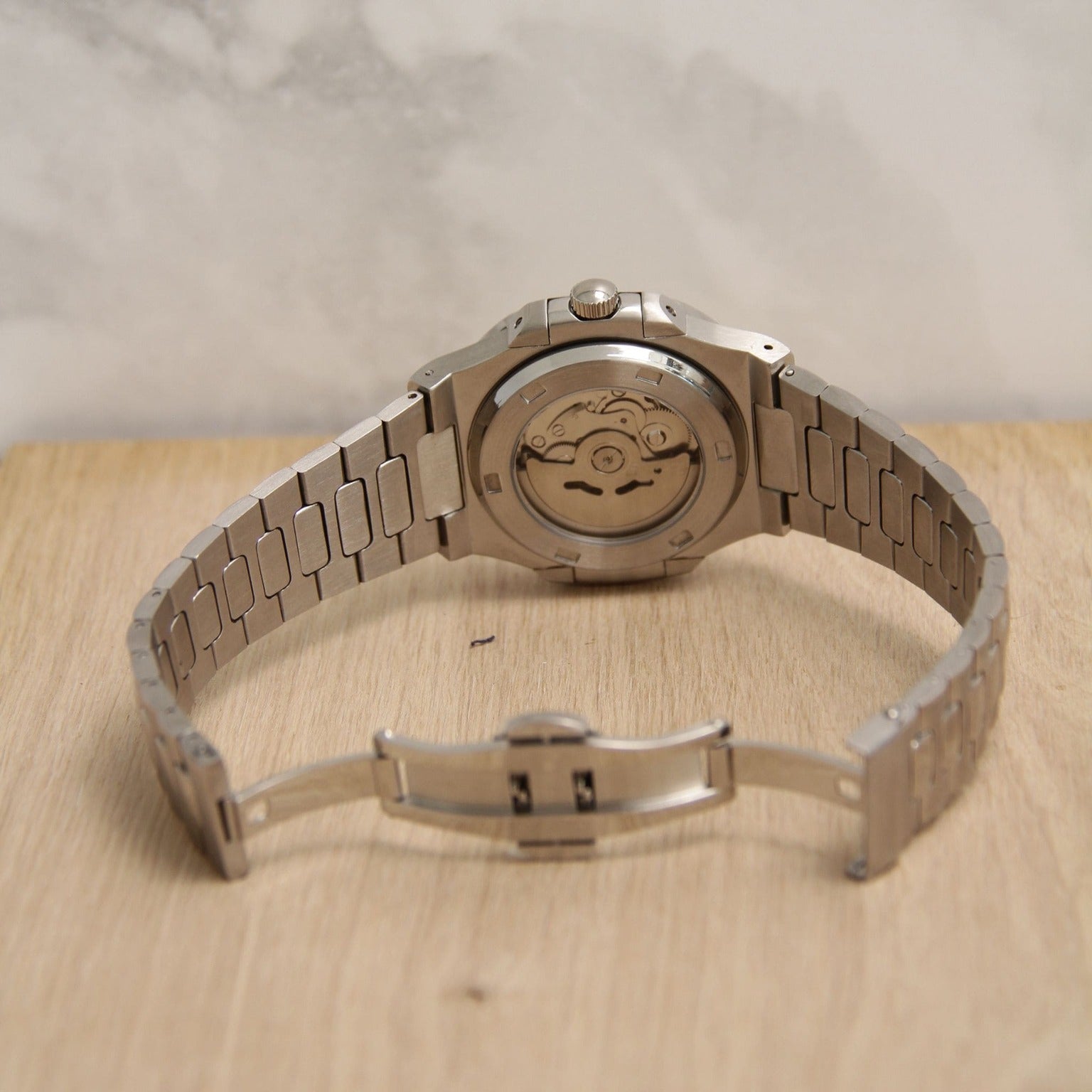 Rear view of Seiko mod Nautilus green metallic with open case back displaying rotor engraving