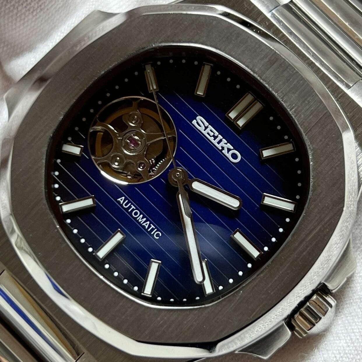 Dial close-up Seiko Mod Nautilus Royal Blue Open Heart emphasizing open balance wheel and luminous markers
