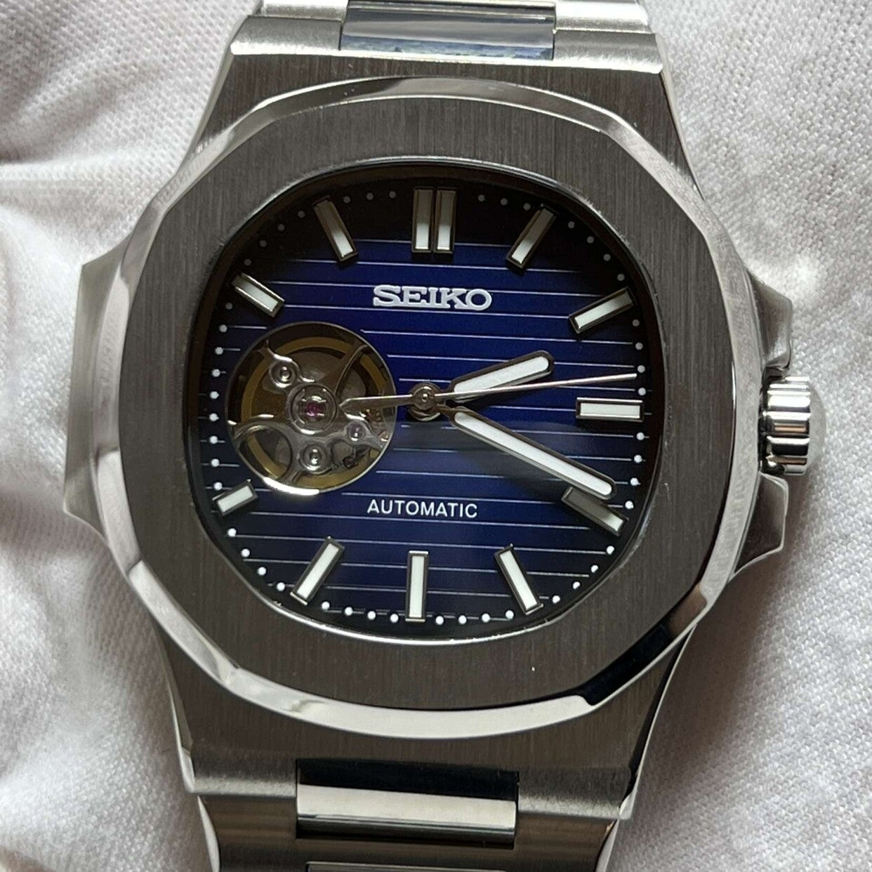 Straight-on front view Seiko Mod Nautilus Royal Blue Open Heart showing polished bezel and horizontal blue texture