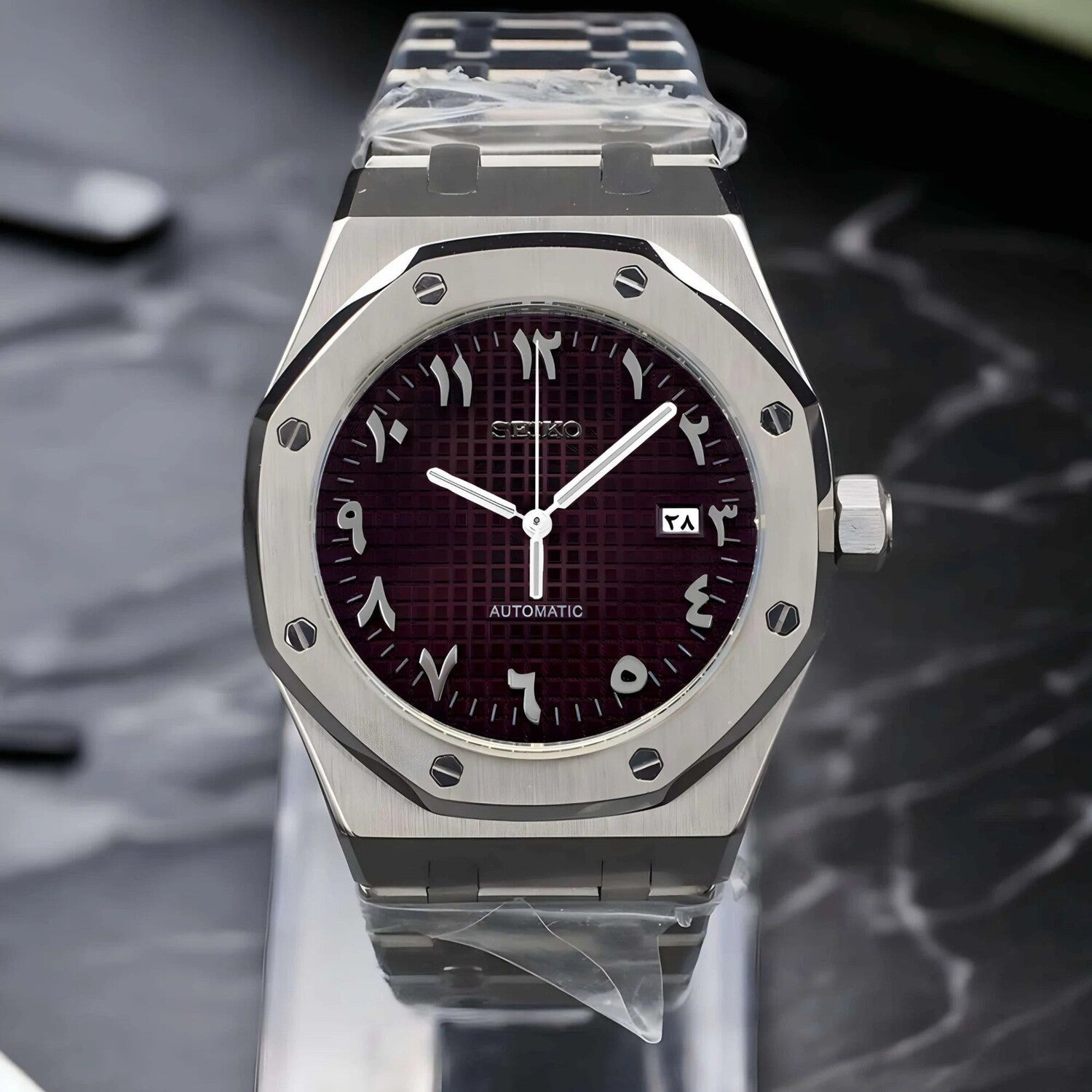 Front view of the Seiko Mod Royal Oak showcasing a brushed stainless steel case, brown textured dial with Arabic numerals, and polished silver tone hands.