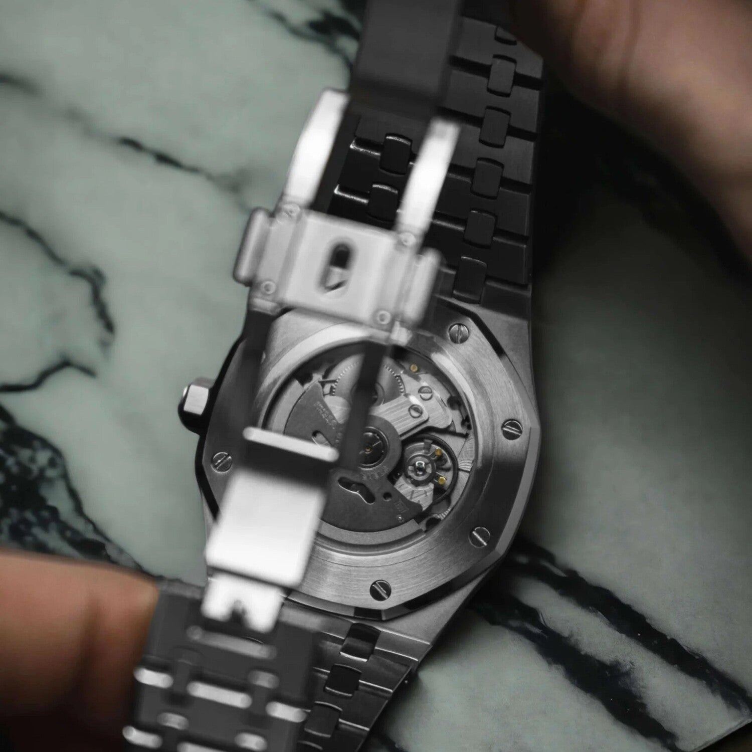 Close up of the Seiko Mod Royal Oak brown Arabic edition showcasing the NH35 automatic movement through its transparent case back and brushed steel clasp.