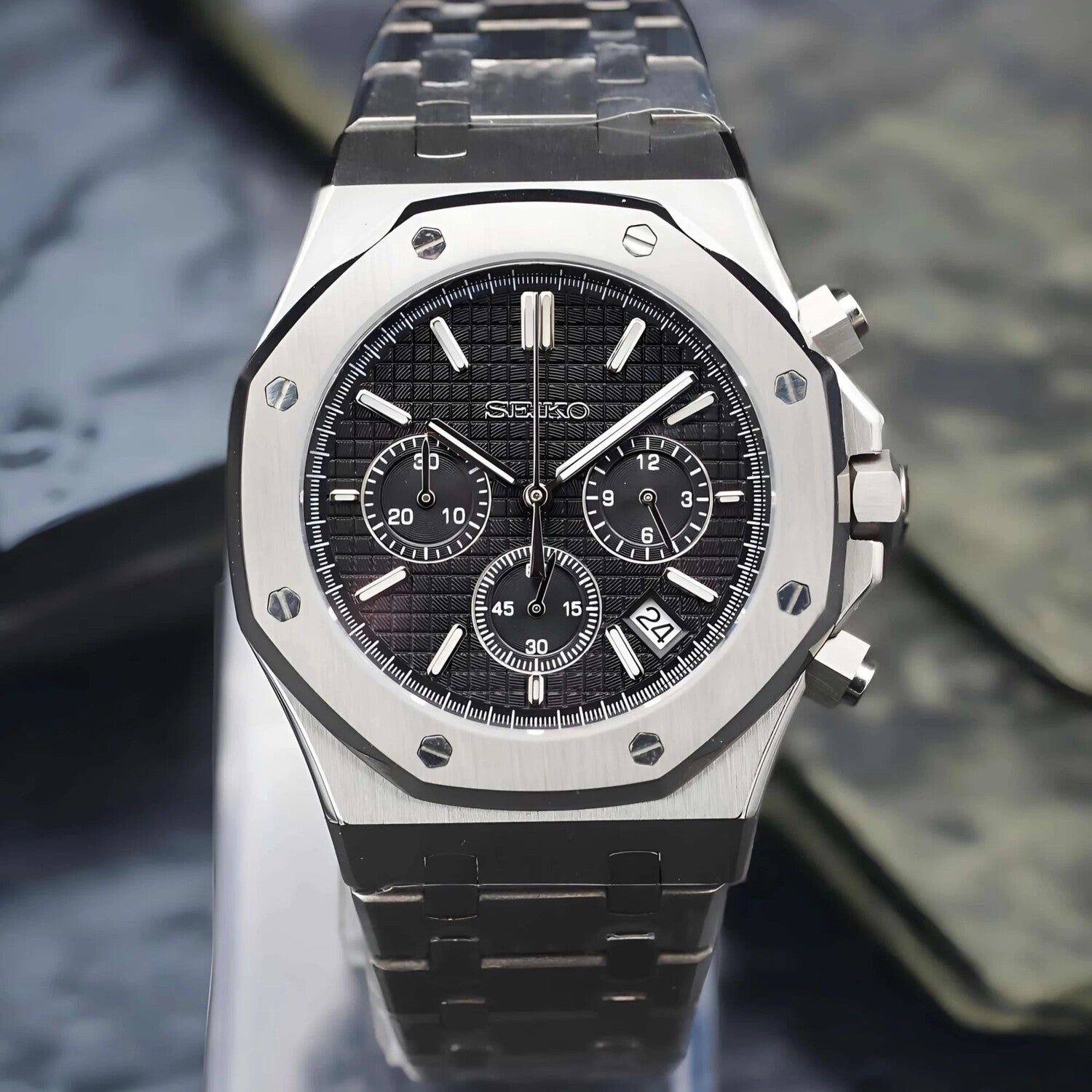 Front facing view of the Seiko Mod Royal Oak VK63 mecha quartz chronograph with black textured dial, three subdials, stainless steel bracelet, and date window at 10 o’clock