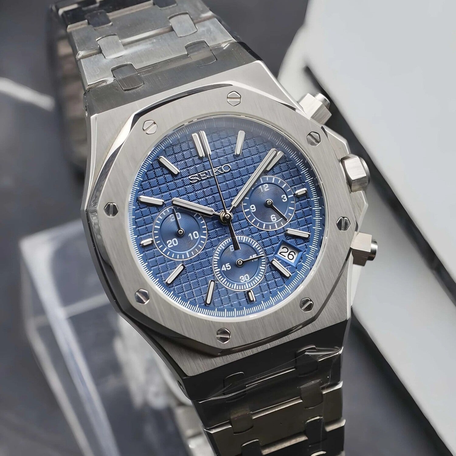 Side view of the Seiko Mod Royal Oak VK63 chronograph showcasing a blue textured dial with three subdials, polished pushers on the right side, brushed stainless steel bracelet, and a small date aperture near 4 o’clock