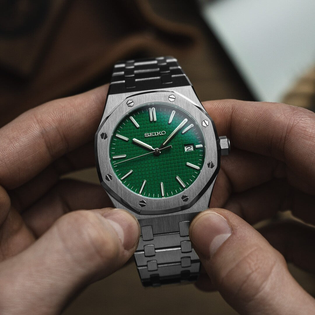 Front view of the Seiko Mod Royal Oak with a striking green patterned dial, brushed stainless steel case, and octagonal bezel, held in both hands for closer inspection.