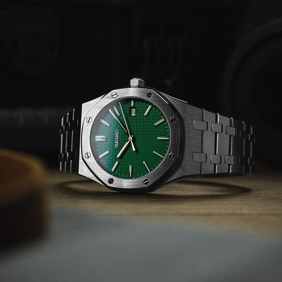 Horizontal view of the Seiko Mod Royal Oak featuring a vivid green textured dial, brushed stainless steel octagonal bezel, date display, and integrated steel bracelet resting on a wooden surface.