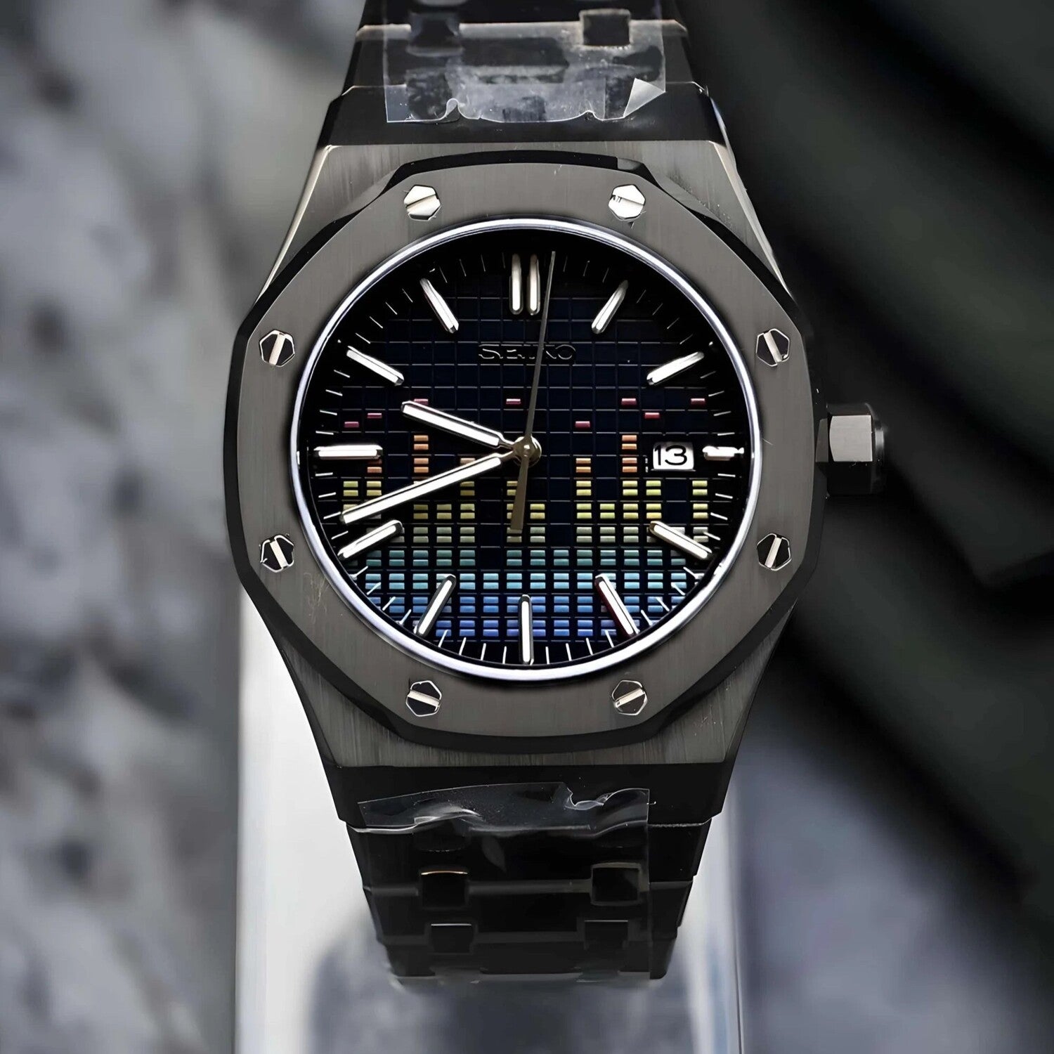 Front view of a Seiko Mod Royal Oak watch featuring a unique "music equalizer" dial design in black with multicolored gradient accents, stainless steel octagonal bezel with visible screws, and a black stainless steel bracelet.