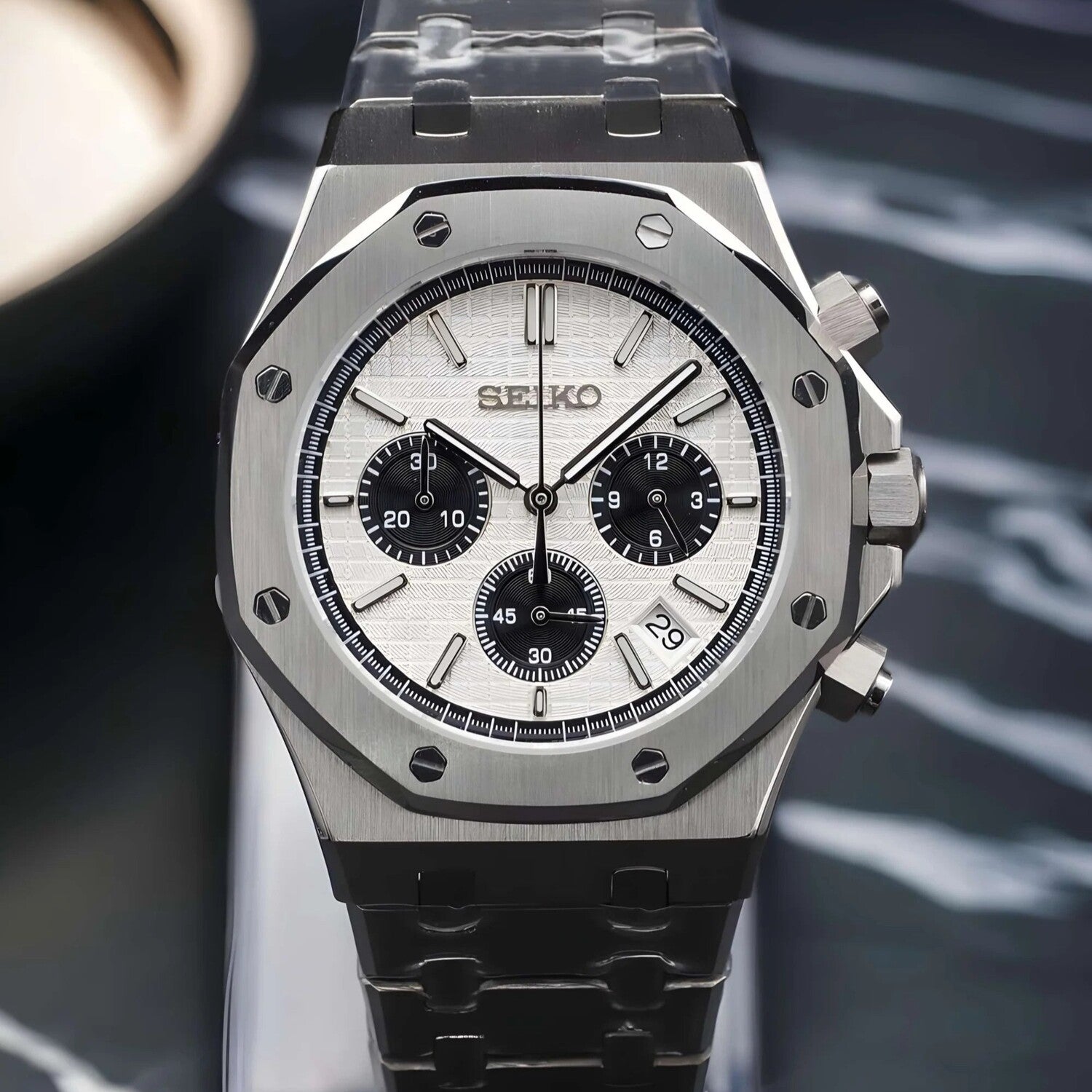 Front view of the Seiko Mod Royal Oak Panda chronograph with white textured dial, contrasting black subdials, octagonal brushed stainless steel bezel with exposed screws, steel bracelet, and date window positioned near 4 o’clock.