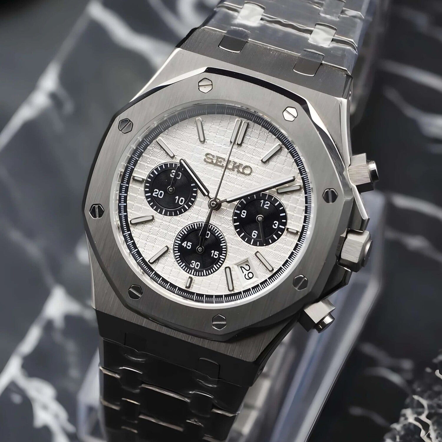 Right angled side view of the Seiko Mod Royal Oak Panda edition, featuring a brushed steel case with octagonal bezel, crisp white textured dial with contrasting black subdials, polished chronograph pushers, integrated stainless steel bracelet, and a small date window at the lower right corner.