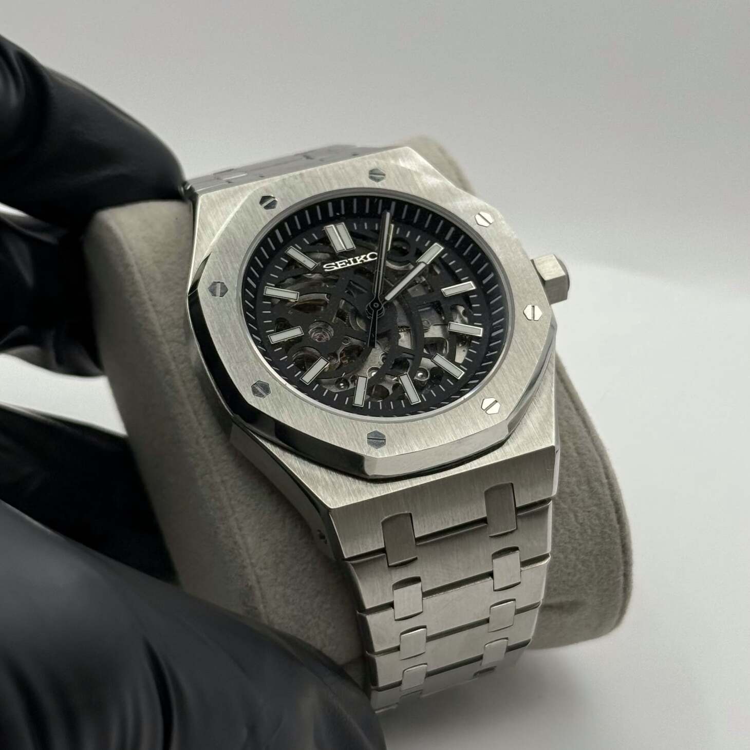 Angled view of Seiko Mod Royal Oak Skeleton in brushed stainless steel with octagonal bezel, showcasing the open-worked dial and visible inner mechanics