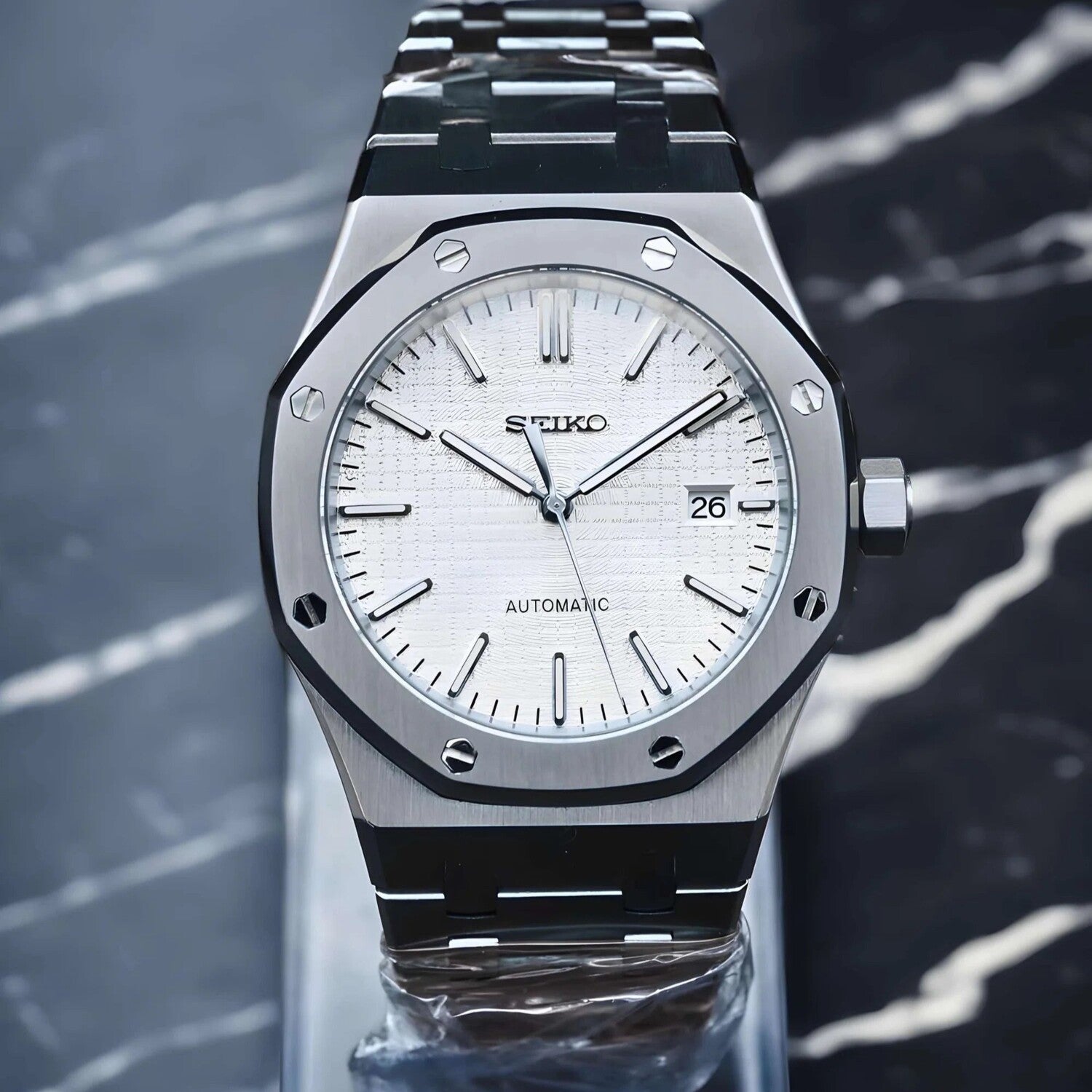 Front view of Seiko Mod Royal Oak in stainless steel, showcasing a textured white dial with baton markers, slim hands and a framed date display.