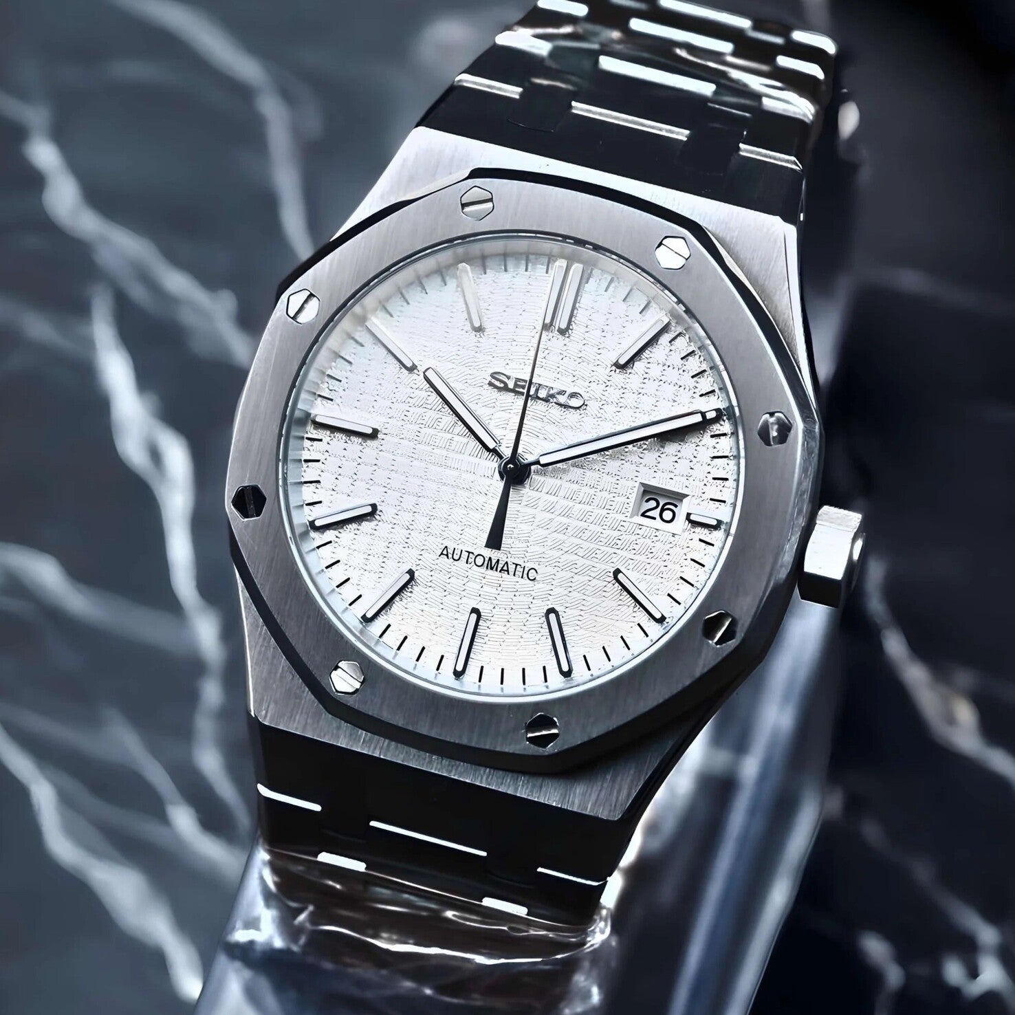 Side perspective of Seiko Mod Royal Oak in brushed steel, highlighting the patterned white dial, applied indices, and angular case shape.