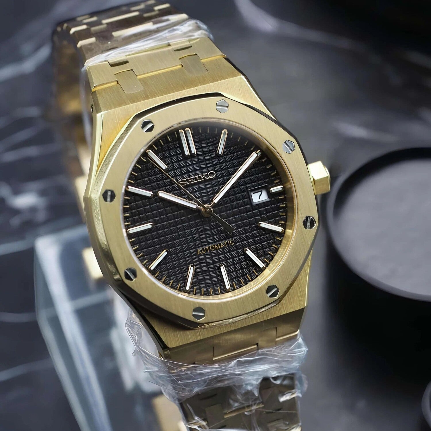 Left angled view of Seiko Mod Royal Oak in yellow gold, showcasing the textured black dial, polished hands, and octagonal bezel.