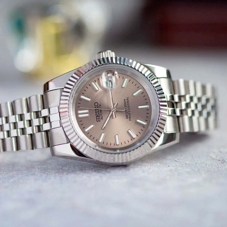 Champagne dial Seiko Mod Datejust on light surface with Jubilee bracelet and polished steel case
