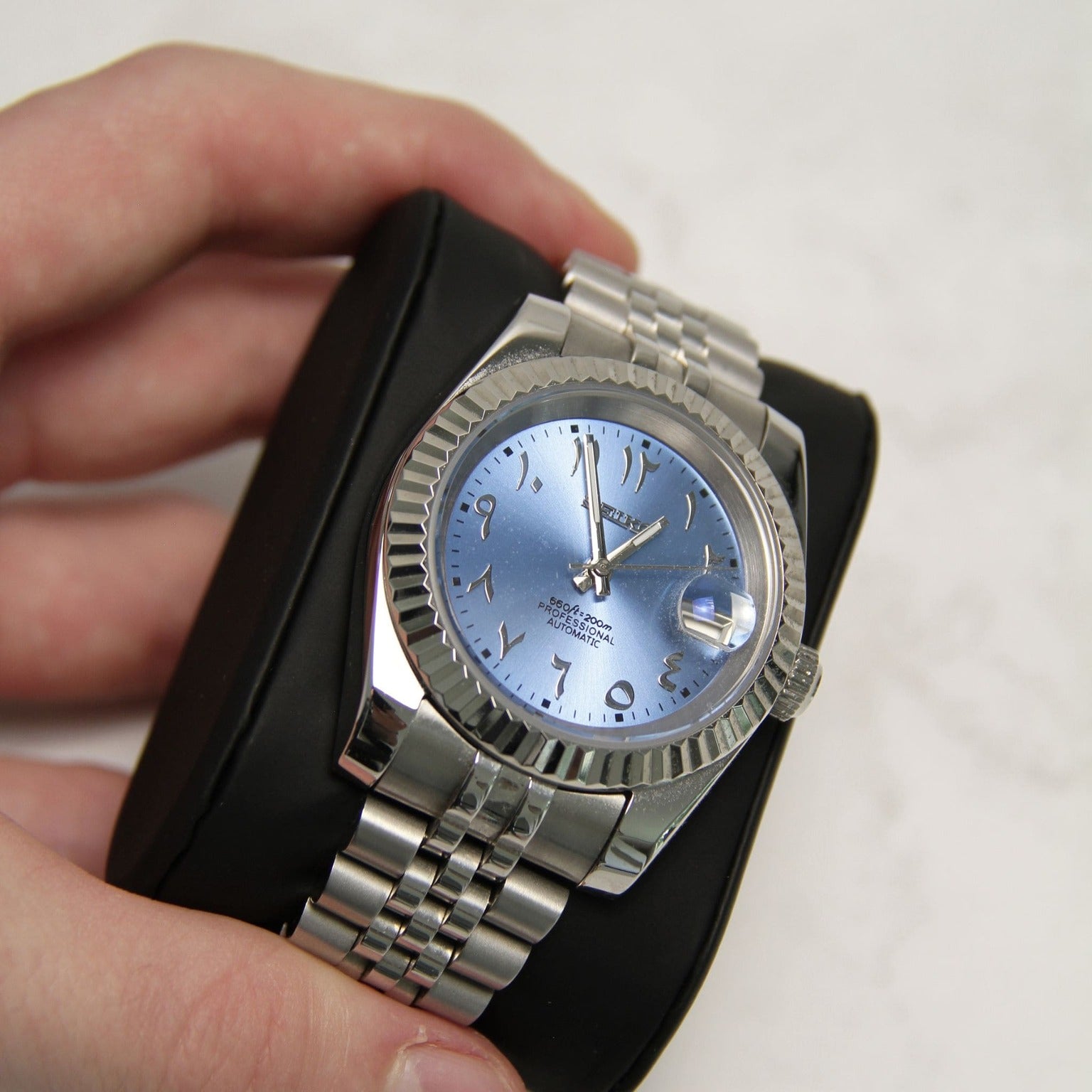 Left angled close up of Seiko Mod Datejust Ice Blue Arabic dial and polished bezel on bracelet