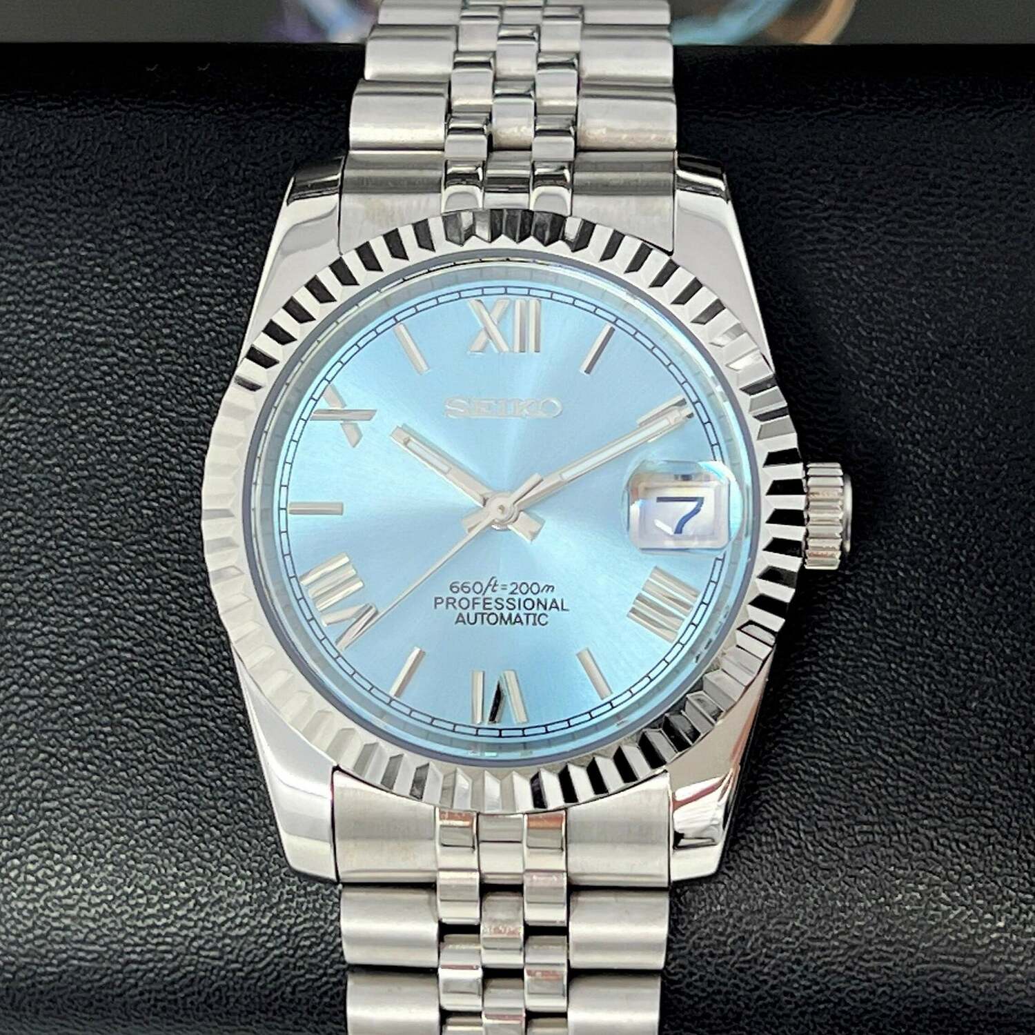Seiko Mod Ice Blue Roman dial close up on black cushion with fluted bezel