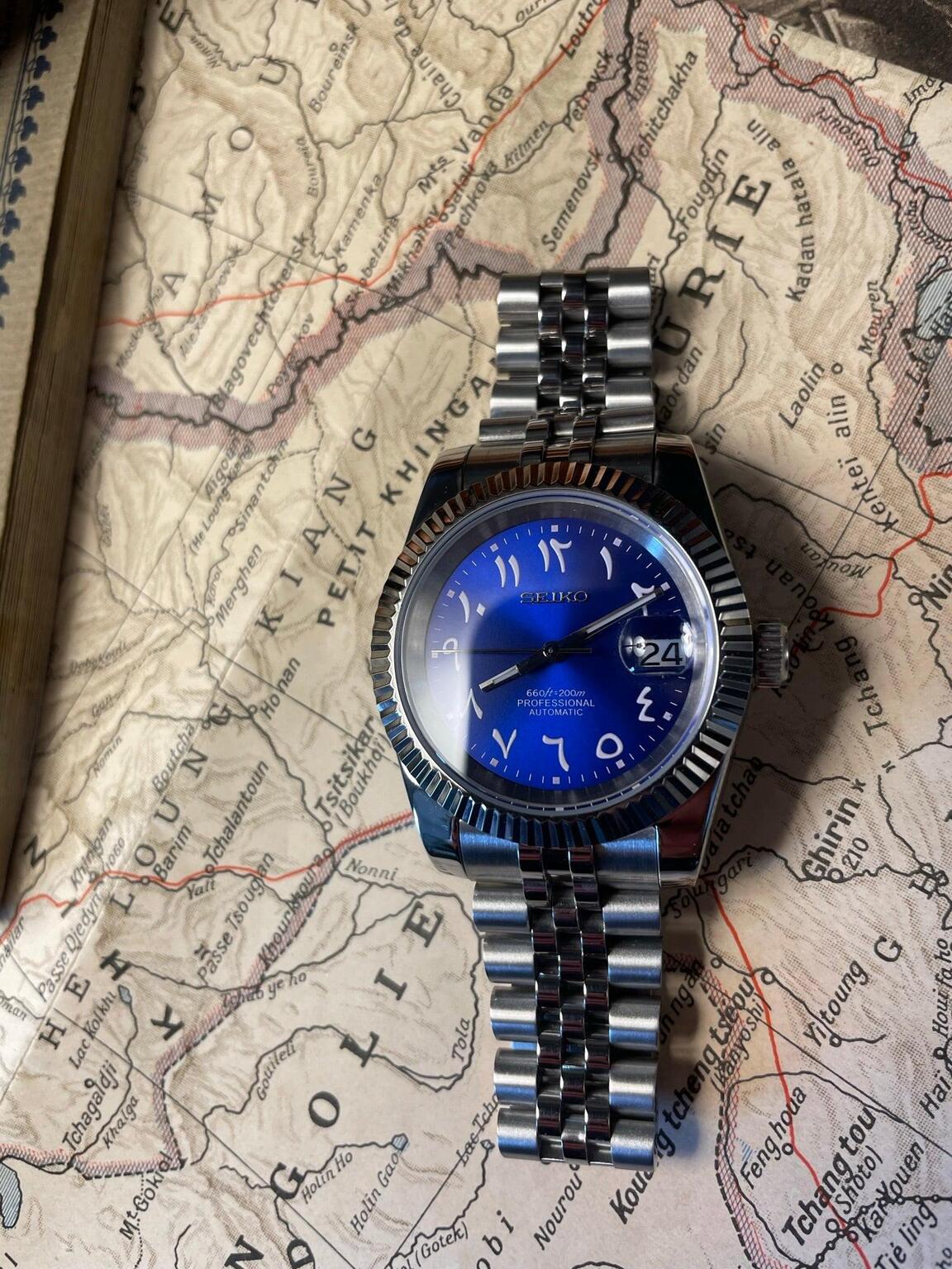 Seiko Mod Datejust Royal Blue Arabic top view on map surface showing jubilee bracelet links