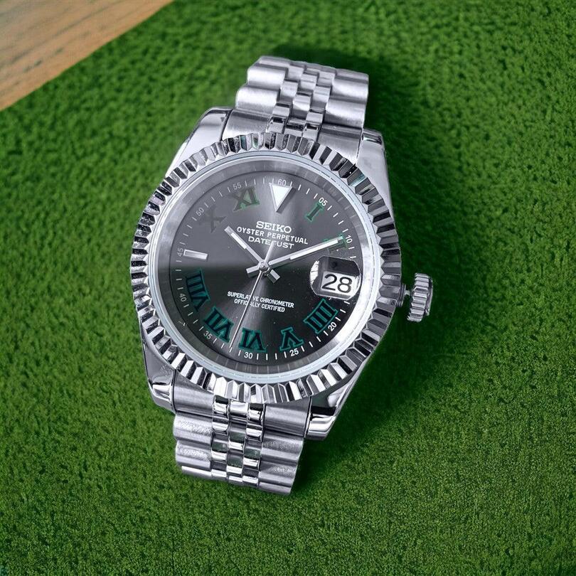 Top view shot of Seiko Mod Datejust Wimbledon laid on green surface, showing bracelet and luminous dial details.