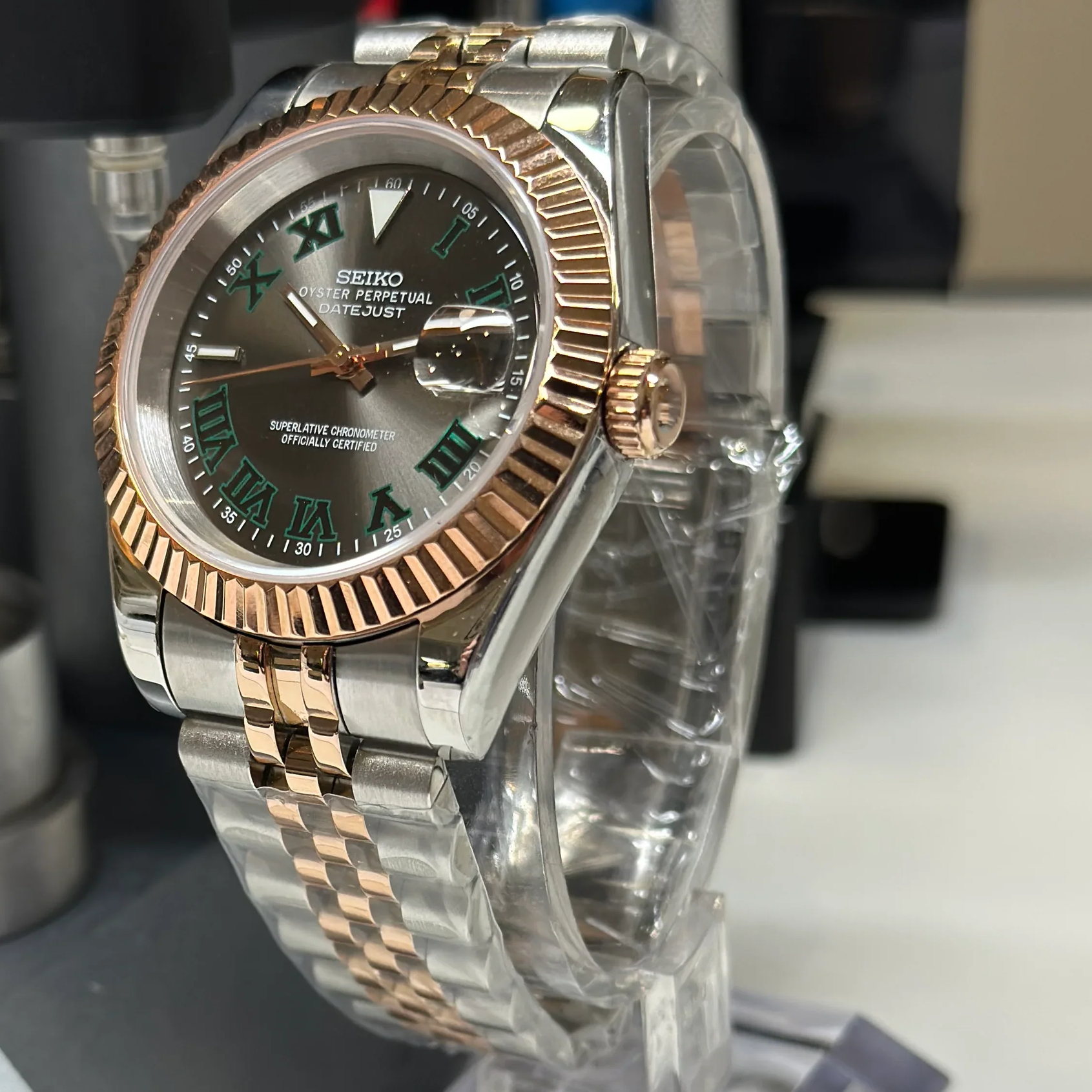 Seiko mod Datejust Wimbledon rose and steel case green Roman numerals on clear stand