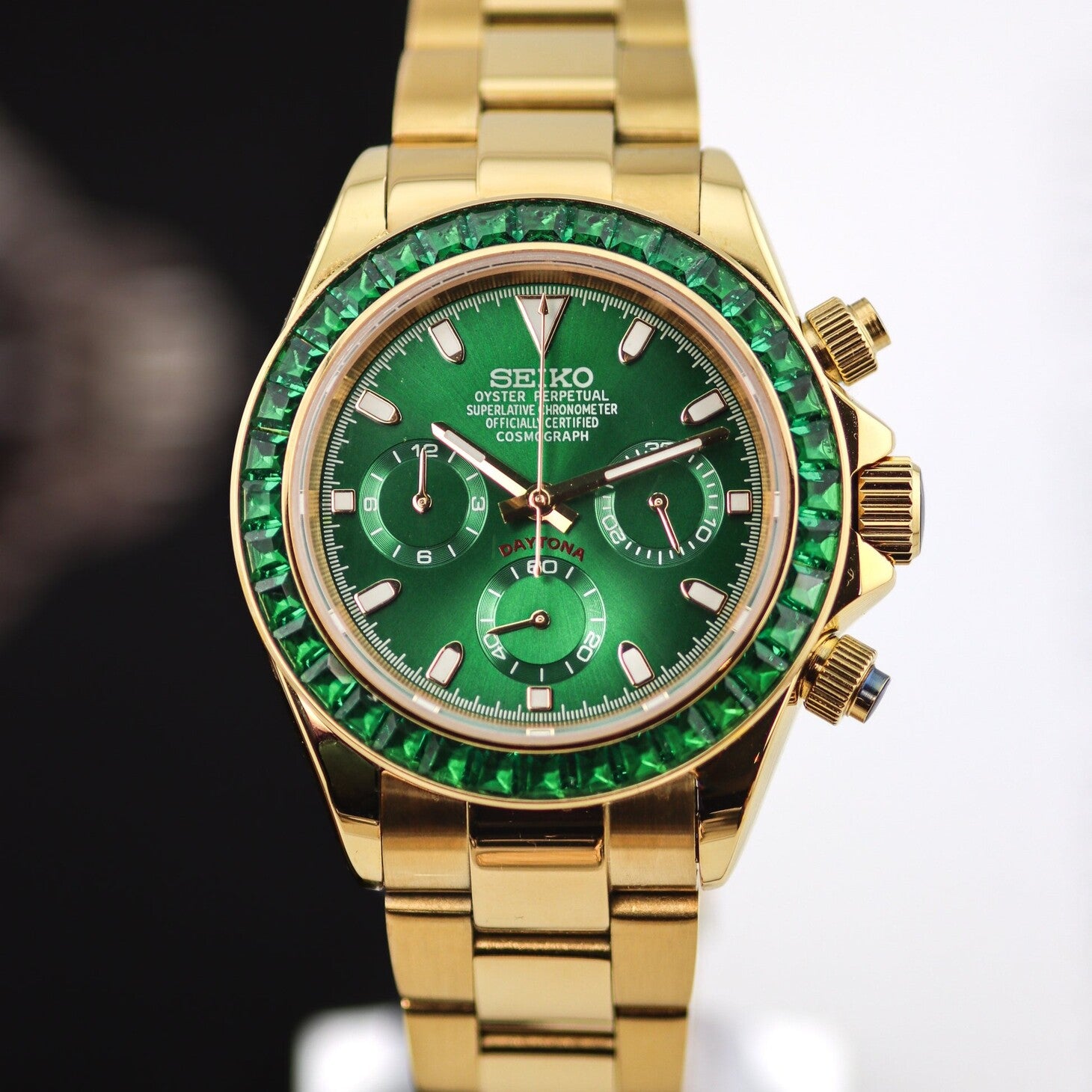 Seiko Moddys Daytona Green Emerald close-up front view with gold case, emerald-set bezel, green dial and three subdials.