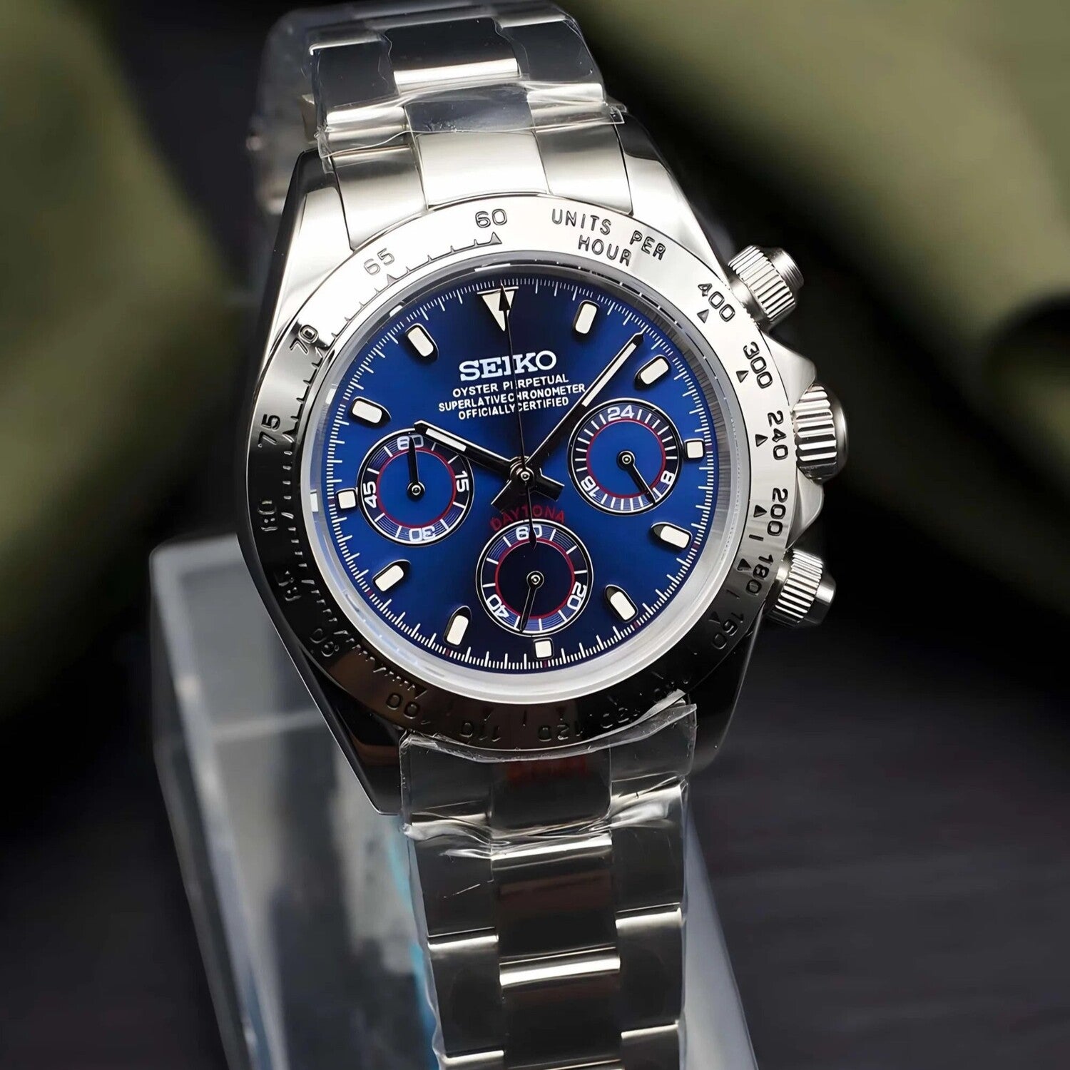 Seiko Mod Daytona Royal Blue shown in left angled view with metallic blue dial, silver subdials accented in red, stainless steel bezel with tachymeter scale, and polished steel bracelet.