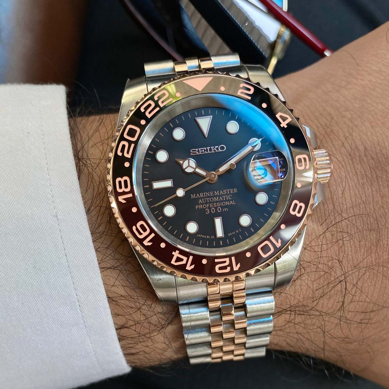 Wrist shot Seiko Mod GMT Rootbeer with two tone jubilee bracelet and chocolate bezel in daylight