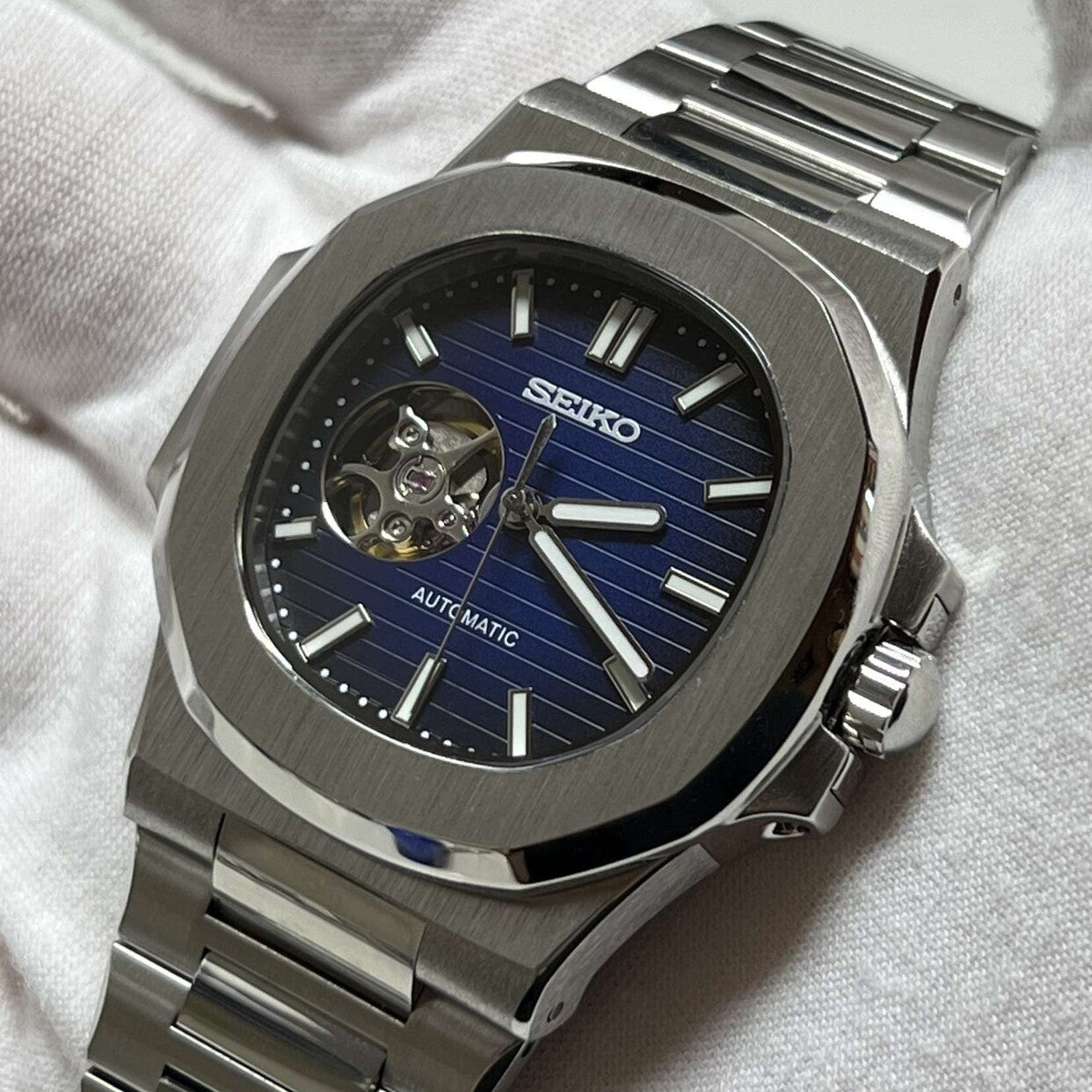 Right-angled view Seiko Mod Nautilus Royal Blue Open Heart highlighting crown and brushed finishing